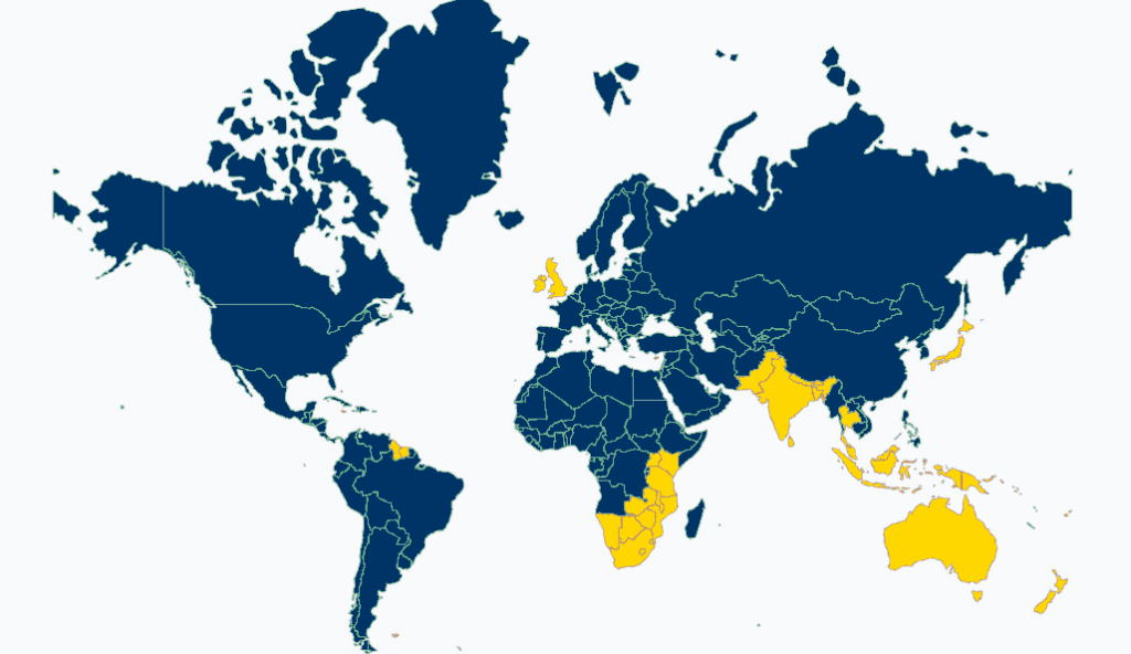 Mappa mondiale che distingue i Paesi con guida a sinistra (evidenziati in giallo, principalmente Regno Unito, Irlanda, Malta, Cipro, India, Australia, Nuova Zelanda, Sudafrica, Giappone e diverse nazioni insulari) da quelli con guida a destra (in blu).
